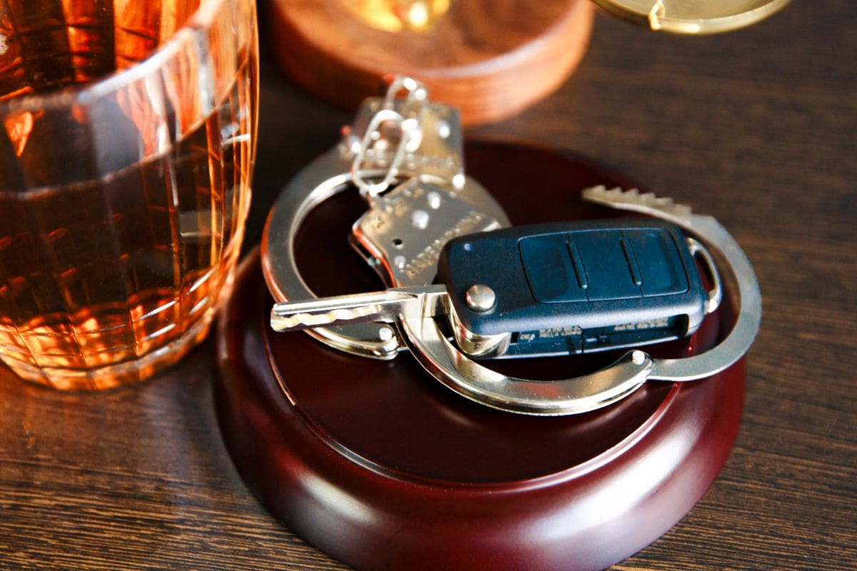 A wooden holder with keys and a car key on it.