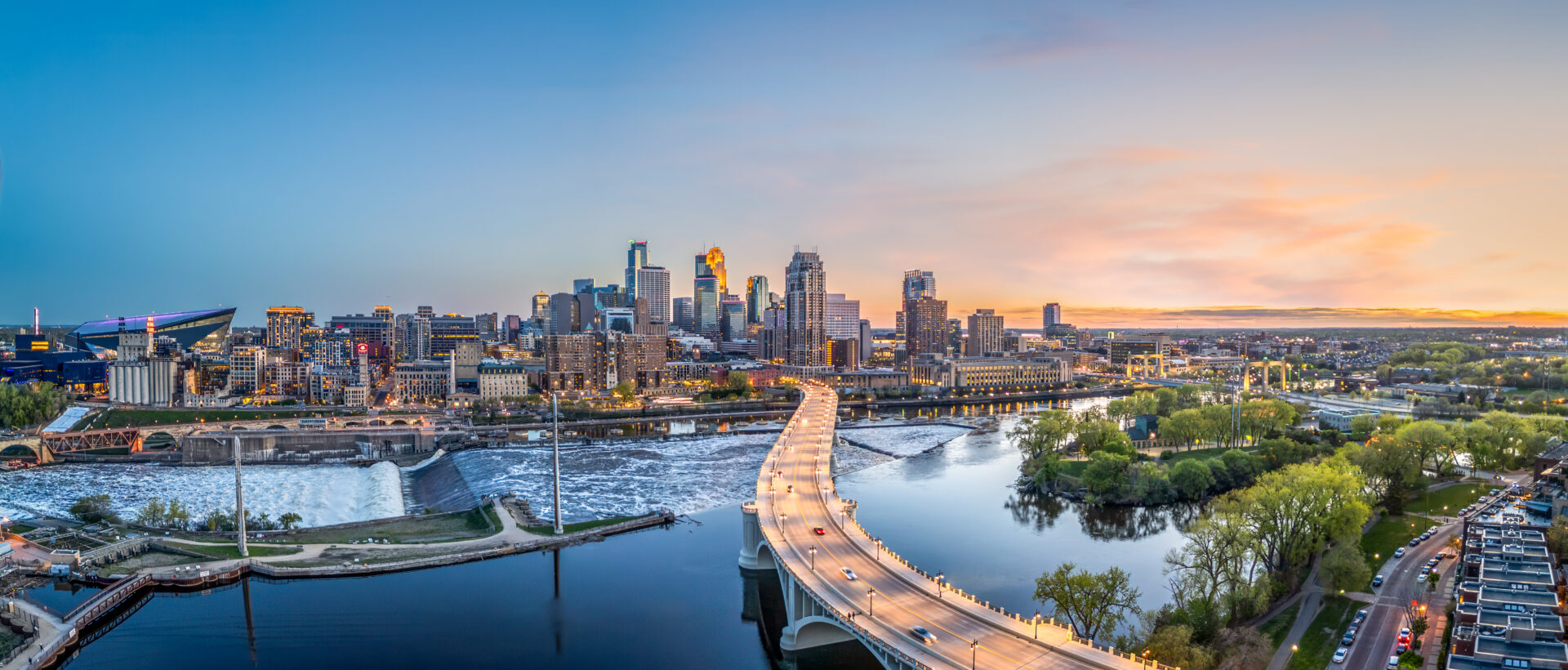 A bridge over water with city skyline in the background.