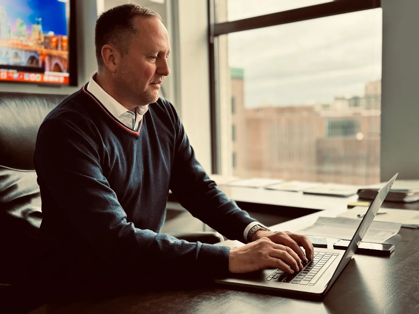 A man sitting at a table with a laptop.