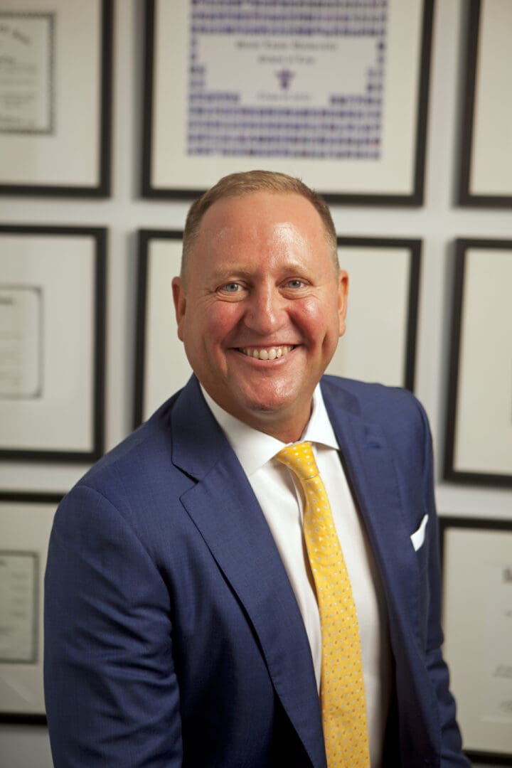 A man in a suit and tie smiling for the camera.